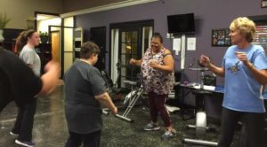Sherri Brothers, executive director of The Arc of Kentucky, participates in a fitness class with another instructor and two students..