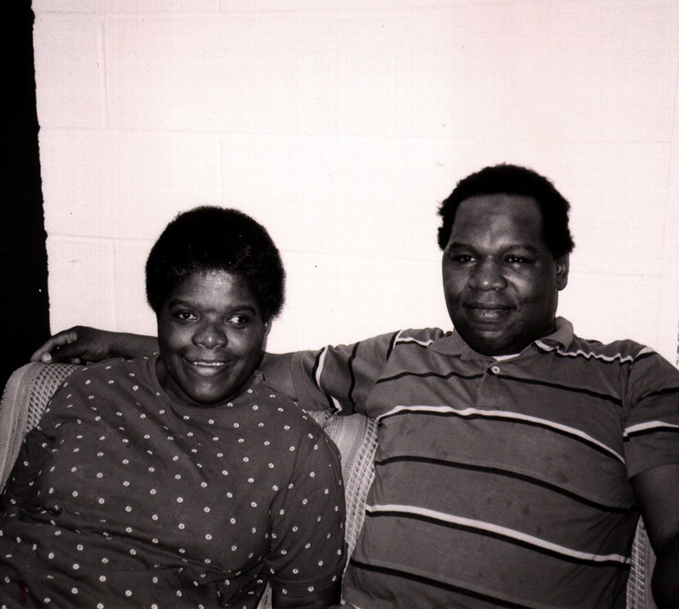 Black and white photo of smiling African-American couple sitting on a couch