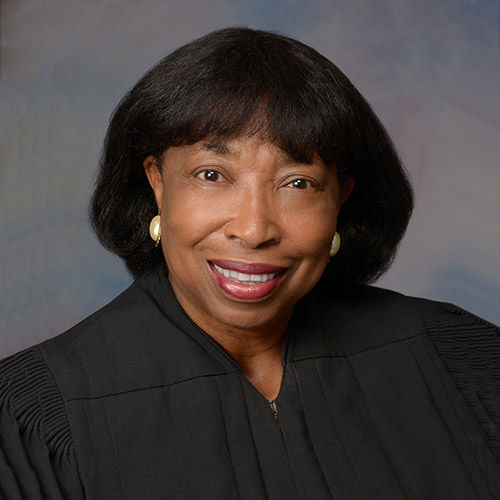 Head shot in front of a woman wearing a judges court dress