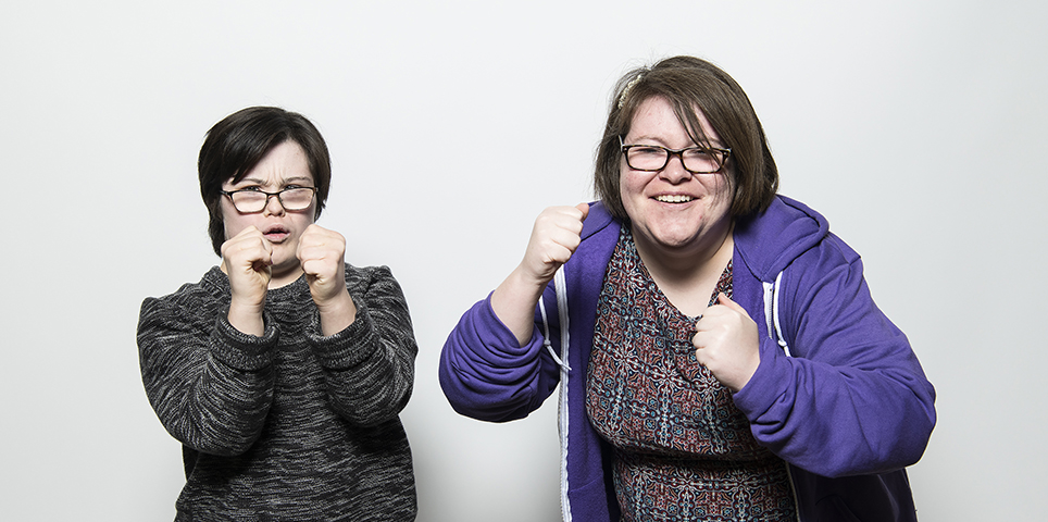 Two woman with clenched fists smile and pretend to box