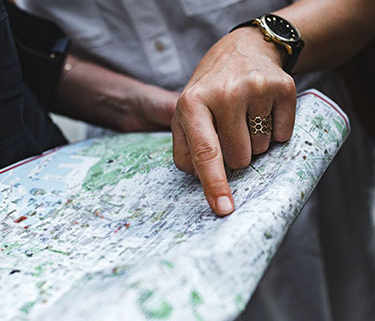 Hand pointing to place on map as another person holds the map