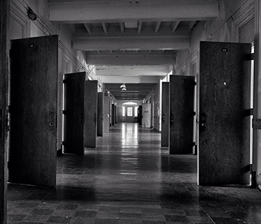 Black and white photograph of a hallway with open doors
