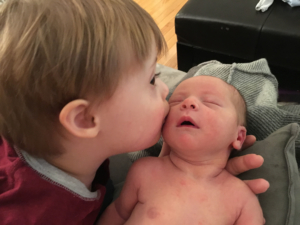 A young boy, Jack, kisses his newborn baby brother.