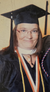 A woman wearing a graduation cap and gown. 