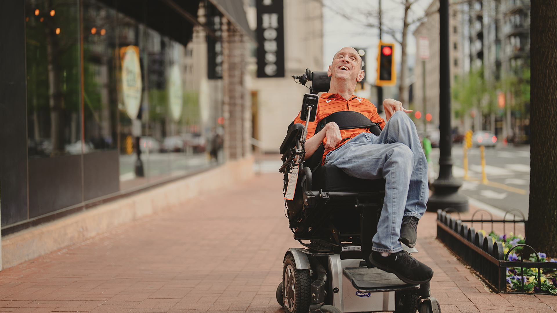 Man with cerebral palsy outside smiling warmly.