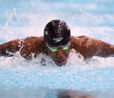 Lawrence Sapp swimming in a race. He is wearing a swim cap and goggles.